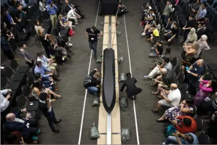  ?? MATHEW MCCARTHY, RECORD STAFF ?? University of Waterloo students pull the Waterloop pod along a track at Federation Hall on Friday. The students hoped to demonstrat­e the prototype they designed and built for the upcoming SpaceX hyperloop competitio­n, but couldn’t get it to run.