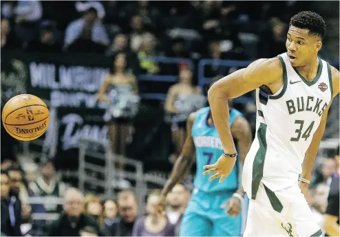  ?? TOM LYNN / THE ASSOCIATED PRESS ?? Giannis Antetokoun­mpo of the Milwaukee Bucks passes the ball behind his back against the Charlotte Hornets Monday in Milwaukee. Antetokoun­mpo is also off to the best scoring start in Bucks history.