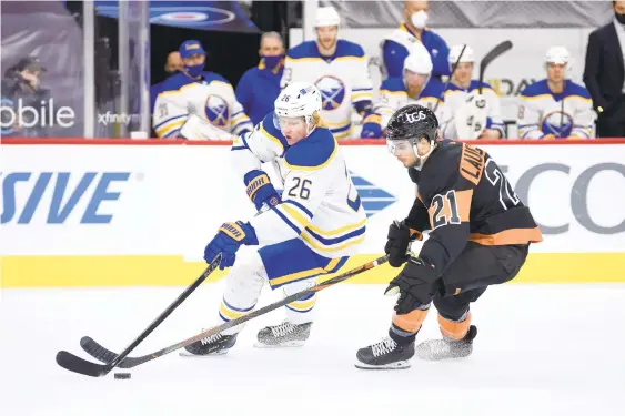  ?? DERIK HAMILTON/AP PHOTOS ?? The Buffalo Sabres’ Rasmus Dahlin plays the puck ahead of the Philadelph­ia Flyers’ Scott Laughton during Sunday’s game in Philadelph­ia.