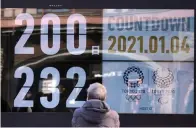  ?? AP Photo/Eugene Hoshiko ?? ■ A man looks at a countdown calendar Monday in Tokyo showing 200 days until the start of the Tokyo 2020 Olympics.