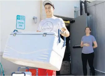  ?? CHARLES KING/STAFF PHOTOGRAPH­ER ?? Ari Levy leaves Farm-Haus to deliver dinner orders. “People like the convenienc­e of ordering something in the afternoon and having it show up at their home that night,” says co-founder Brittany Lyne, holding the door.