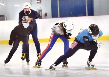  ?? Dan Watson/The Signal ?? (Above) Santa Clarita Speed Skating Club member Solomon Kim, 18, right, leads the pack of skaters, from left, Peter Smokler, 74; Kyle Song, 10; and Abigail Han, 11, as they practice at The Cube in Valencia on Wednesday. (Below) Club member Emma Coppess, 19, practices figure skating at the Valencia ice rink.