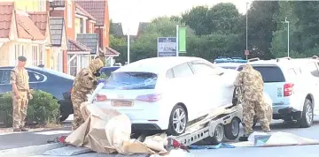  ??  ?? Military personnel arranging the transporta­tion of a car in relation to the ongoing nerve-agent incident in Amesbury, in Swindon, Britain in this photo obtained from social media. — Reuters photo