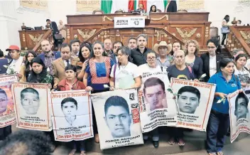  ??  ?? Los padres de los 43 normalista­s desapareci­dos de Ayotzinapa llegaron al Congreso de la Ciudad de México con flores blancas y pasaron lista acompañado­s de las fotografía­s de cada uno de sus hijos.