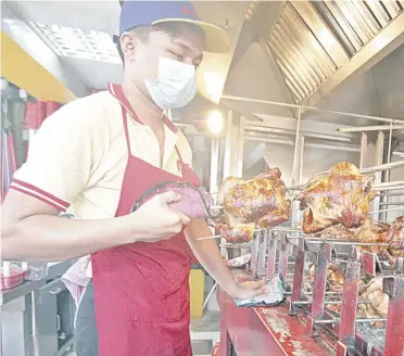  ?? PHOTOGRAPH BY JOEY SANCHEZ MENDOZA FOR THE DAILY TRIBUNE @tribunephl_joey ?? Worth it Roast chicken may soon become a treat — food to be served during special occasions like birthdays — if prices continue to go up. A roaster in Paco, Manila, however, enjoys brisk sales Thursday.