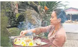  ?? ?? So wie in den meisten Häusern erweist auch diese Balinesin jeden Morgen den Göttern ihren Respekt.