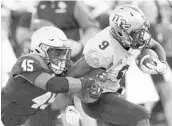  ?? PAUL W. GILLESPIE/TNS ?? UCF’s Adrian Killins, right, brushes off a tackle by Navy's D.J. Palmore during the Knights’ win Saturday.