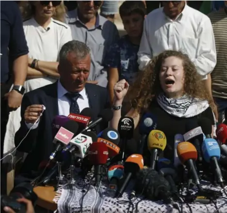  ??  ?? Ahed Tamimi gaf in haar dorp Nabi Saleh een persconfer­entie, geflankeer­d door haar vader Bassam (l.)en haar moeder Nariman.