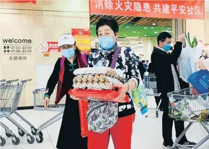  ?? WANG ZHAO / AFP ?? Una clienta d’un supermerca­t de Pequín amb un carregamen­t d’ous