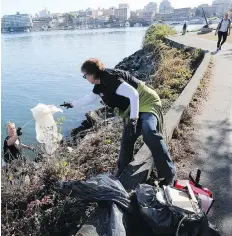  ??  ?? Tereza Ticha, left, and Sheila Neapole collect garbage from the Inner Harbour as part of the Clean Up the Shores effort this month.