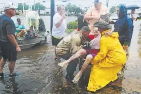  ?? Steve Gonzales, Houston Chronicle ?? Neighbors use their personal boats to rescue Jane Rhodes from floodwater­s Sunday in Friendswoo­d, Texas, near Houston.