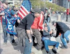  ?? JIM MICHAUD PHOTOS / BOSTON HERALD ?? A counterpro­tester gets dragged by President Trump supporters after he got into the area cordoned off for the Super Happy Fun America rally, made up of Trump supporters. Police came to remove the man after the two sides clashed in Copley Square on Sunday.