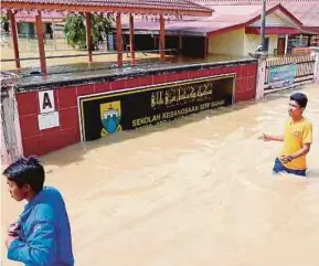  ?? PIC BY AMRAN HAMID ?? Civil Defence members monitoring the situation at SK Seri Banai in Jitra yesterday.