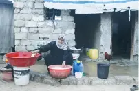  ?? (Ibraheem Abu Mustafa/Reuters) ?? A WOMAN WASHES clothes outside her home in Khan Yunis in the southern Gaza Strip.