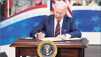  ?? Patrick Semansky / Associated Press ?? President Joe Biden signs the “Accelerati­ng Access to Critical Therapies for ALS Act” into law during Thursday’s ceremony at the White House in Washington, D.C.