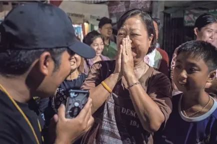  ??  ?? Onlookers in front of Chiangrai Prachanukr­oh Hospital in Thailand watch and cheer Tuesday as ambulances transport the last rescued schoolboys and their coach from a nearby helipad. Divers brought out the last of the 12 boys and their coach Tuesday after the group had been trapped in a cave since June 23.