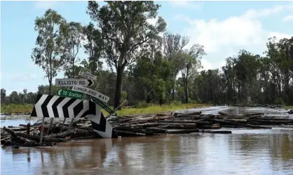  ?? Photograph: Saeed Khan/AFP/Getty Images ?? Logs swept away in floods block a road near an overflowin­g Richmond river outside Lismore in northern NSW last month. Fish kills occurred in the river after the flooding led to a lack of oxygen along a 60km stretch.