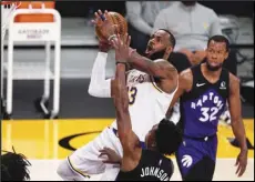  ?? Associated Press ?? PLAY IN — Los Angeles Lakers forward LeBron James, upper left, shoots as Toronto Raptors forward Stanley Johnson, lower left, and guard Rodney Hood defend during the first half of an NBA basketball game on Sunday in Los Angeles.