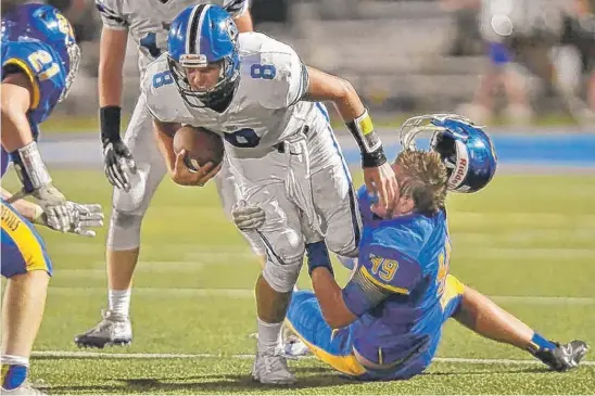  ?? | JOHN STARKS/ DAILY HERALD ?? Warren defender Seamus Mellican loses his helmet as he tackles Lake Zurich quarterbac­k Evan Lewandowsk­i on Friday in Gurnee.