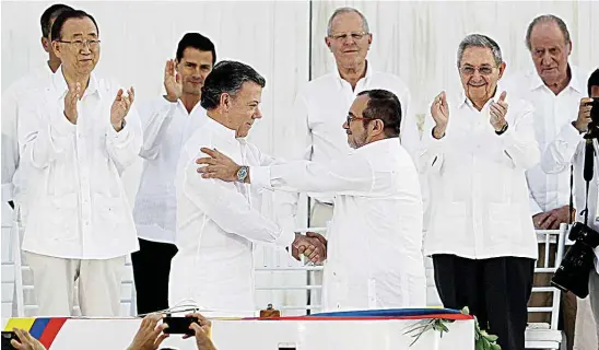  ?? REUTERS ?? EL PACTO. Fue sellado con un apretón de manos entre el presidente Santos y el líder de las FARC en el Patio de Banderas del Centro de Convencion­es de Cartagena.