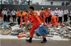  ?? GETTY IMAGES ?? Search and Rescue personnel examine recovered debris and personal items from Lion Air flight JT 610 at the Tanjung Priok port in Jakarta.