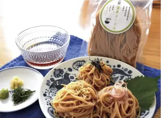  ?? Yomiuri Shimbun photos ?? Above: Brown rice noodles
Below: Daisuke Seko pours a hot beverage made from roasted brown rice.