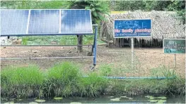  ??  ?? A sign echoing the school founder’s campaign for family planning is seen next to a solar cell panel, which is a source of power for the school.