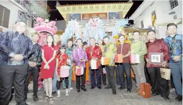  ??  ?? Yong (front, sixth right) holds a lantern in front of a Chinese temple at Carpenter Street along with officials and local community leaders who accompanie­d him.