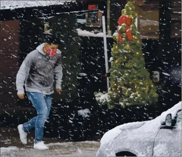  ?? BILL SIKES — THE ASSOCIATED PRESS ?? A man runs through heavy snow Saturday in downtown Marlboroug­h, Mass. The northeaste­rn United States is seeing the first big snowstorm of the season.