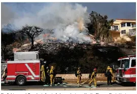  ?? MARIO TAMA / GETTY IMAGES ?? Firefighte­rs work Tuesday in front of a home destroyed by the Thomas Fire in Ventura, Calif. Around 50,000 acres have burned in the fire, forcing thousands to evacuate and destroying 150 structures.