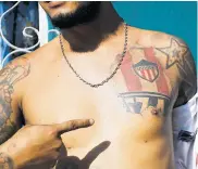  ??  ?? Elvis Viña muestra uno de sus tatuajes del Junior.