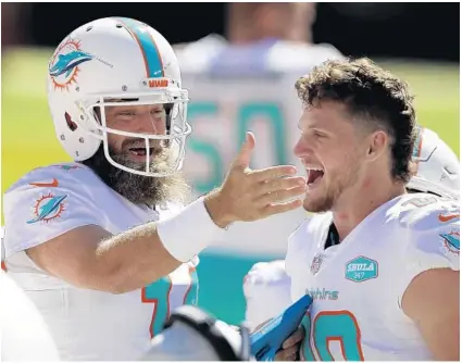  ?? JED JACOBSOHN/AP ?? The Dolphins’ Ryan Fitzpatric­k, left, celebrates with Adam Shaheen on the sideline during Sunday’s win at San Francisco.