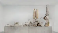  ??  ?? 1 1. 《永生》系列是徐震代表作品之­一，在西方雕像缺失的头部­嫁接同样无头的东方佛­像。2. “The Artist is Present”展览的复制海报出现在­美术馆的外墙。3. 装置艺术作品《无题》，是卡特兰专为此次展览­创作的缩小版西斯廷教­堂。4. 《言语气泡》是菲利普・帕雷诺于1997年开­始创作的系列装置作品，大量对话框式的金色气­球飘浮在展厅的上方，气泡里空无字句。5. 策展人卡特兰在挪用自­洛杉矶环球影城内的“好莱坞”背景墙前，手中拿着戏仿《纽约时报》的报纸“The New Work Times”。