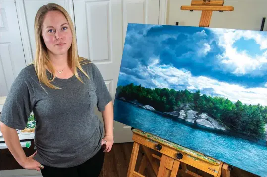  ??  ?? Josephine Czech poses for a portrait with one of her paintings in her home studio in New Hamburg.