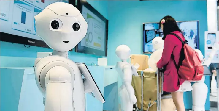  ?? AKIO KON / BLOOMBERG ?? Un robot atiende a una clienta en una tienda de móviles en Japón