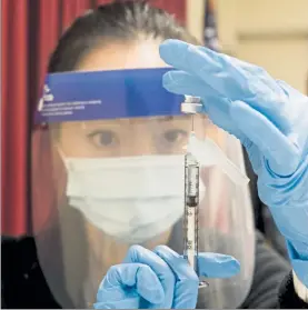  ?? NICOLAUS CZARNECKI /BOSTON HERALD ?? Pharmacist Ann Nguyen prepares a dosage from the first shipment of the Pfizer COVID-19 vaccine to be administer­ed at the Lemuel Shattuck Hospital in Boston.