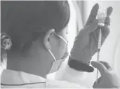  ?? EUGENE HOSHIKO/AP ?? A health worker prepares a dose of the Moderna vaccine on June 30 at Sumida ward of Tokyo.