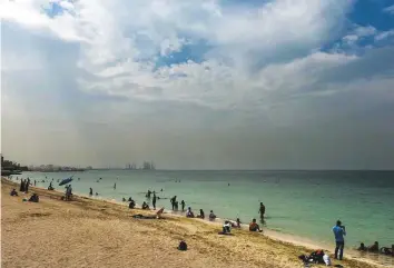  ?? Ahmed Ramzan/Gulf News ?? People enjoying the cloudy weather at Ajman beach on Friday. The Met says by the end of October, the mercury will drop by about one degree on average every two or three days.