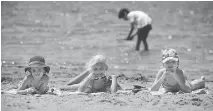  ?? ASHLEY FRASER ?? From left, five-year-old Haley White, seven-year-old Lily Macdonald and eight-year-old Sophia White enjoy the sand at Mooney’s Bay beach. Lifeguards will be on duty until Aug. 27.