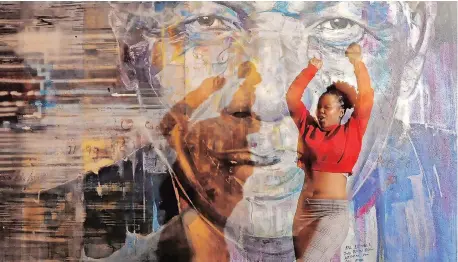  ?? African News Agency (ANA) ?? A WOMAN walks past a mural of Nelson Mandela in Longmarket Street in Cape Town.
| TRACEY ADAMS