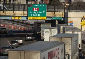  ?? The Associated Press ?? ■ A small line of semi-trailer trucks line up along northbound I-75 Tuesday in Detroit as the Ambassador Bridge entrance is blocked off for travel to Canada.