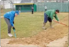  ??  ?? Volunteers prepare one of the fields for opening day.