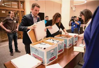  ?? Jessica Phelps/Staff photograph­er ?? Mike Siegel, political director of Ground Game, and Ananda Tomas of ACT 4 SA sort boxes containing 37,000 signatures for their proposed ballot initiative­s for May’s municipal elections.