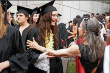  ?? WILLIAM J. KEMBLE PHOTO ?? Zara Ferro of Los Angeles reaches to give her mother, Louise, a hug during Saturday’s Bard College commenceme­nt exercises.