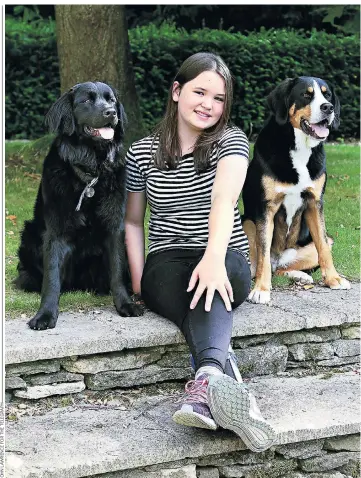  ??  ?? Determined: Maddie Greenwood, 12, pictured at home in Oxford with dogs Bella and August, suffered a stroke when she was three