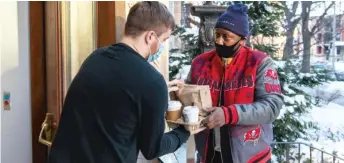  ?? TYLER LARIVIERE/SUN-TIMES ?? Osmond Malcolm, a graduate of Cook County’s RAP drug court, makes a food delivery Wednesday in Hyde Park for GrubHub.