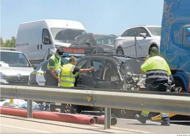  ?? JUAN AYALA ?? Agentes de la Guardia Civil y de los servicios de rescate, junto al vehículo accidentad­o.