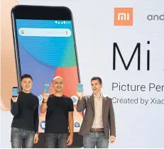  ?? AFP ?? FROM LEFT Donovan Sung, director of product management and marketing at Xiaomi Global, Manu Jain, managing director of Xiaomi India, and global director of Android Partner Programs Jon Gold hold the newly-launched Xiaomi Mi A1 smartphone at a function...