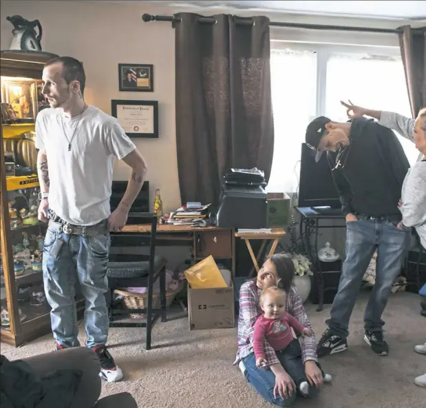  ??  ?? Danielle, far right, flicks the ear of her son, Nick Ashbaugh, 22, while her other son, T.J., far left, picks up his daughter from their house after his weekly trek to addictrek to addiction treatment. On the floor, McClain’s daughter, Grace, holds her...