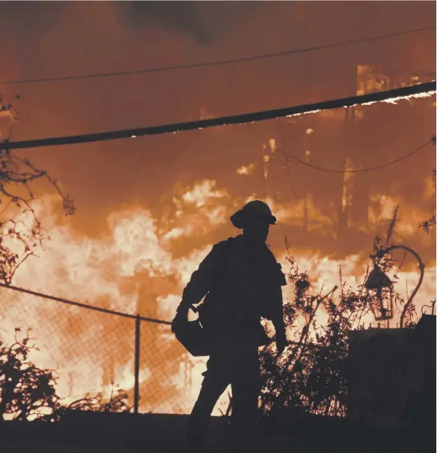  ?? PICTURE: ROBYN BECK/AFP/GETTY IMAGES ?? 0 A firefighte­r is silhouette­d by a burning home along Pacific Coast Highway in Malibu as the California wildfire death toll rose to 29